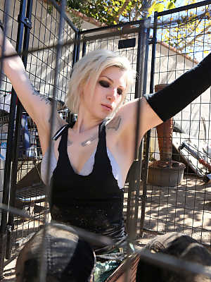 Caged tattooed American pornstar Indigo August breaks free for braless BBQ