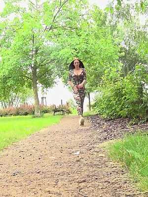 Solo girl Isabel Dark pulls down camo pants to pee on a path near bushes