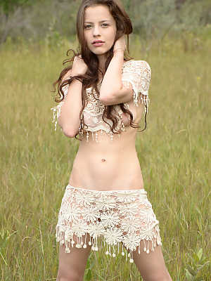 Skinny young girl Iva Nora teases her long hair in a field