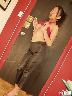 Brunette Asian girl Jade Marcela smokes a cigarette while stripping