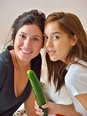 Sweet teen Sophie and her girlfriend play with a big green cucumber