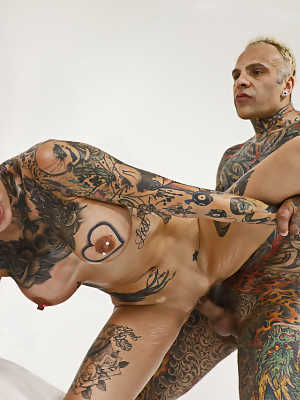 Heavily tattooed couple engage in a spirited fuck while bare naked