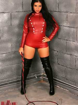 Dark haired domme Jasmine Jones wields a bull whip in latex duds and boots