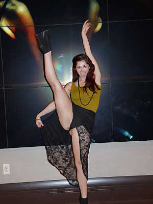 Redheaded babe Jazz Reilly gives an upskirt while showing her flexible body