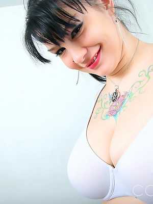 Gorgeous tattooed Jennique slides her huge breasts out of her tight sweater